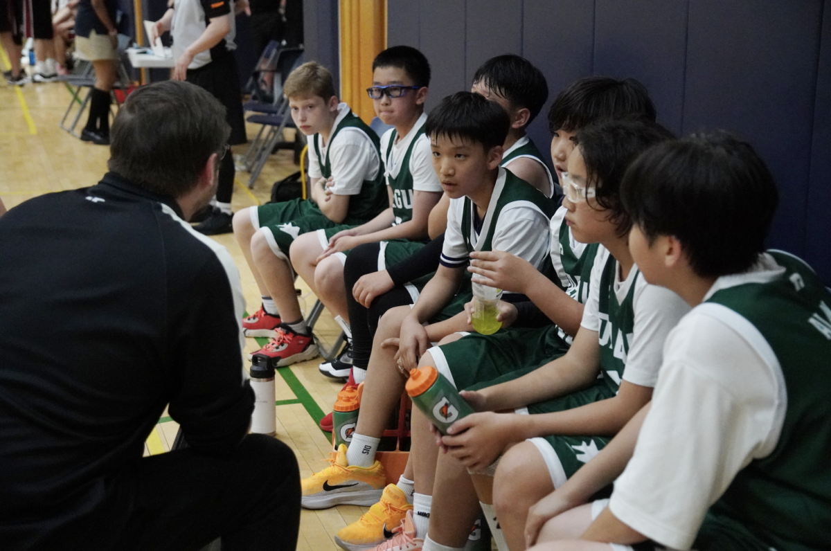 The JV squad listens carefully to Coach Kaschub’s short pep-talk mid game. Although tired, the boys try their best to execute their plays. 
